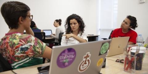 This is a photo of women at a table with laptops.