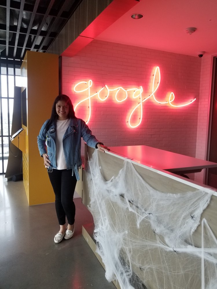 Nathalia standing in front of a neon Google sign.