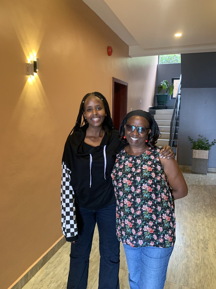 Angela, wearing a black hoodie, poses next to her mother, who’s wearing a floral shirt.